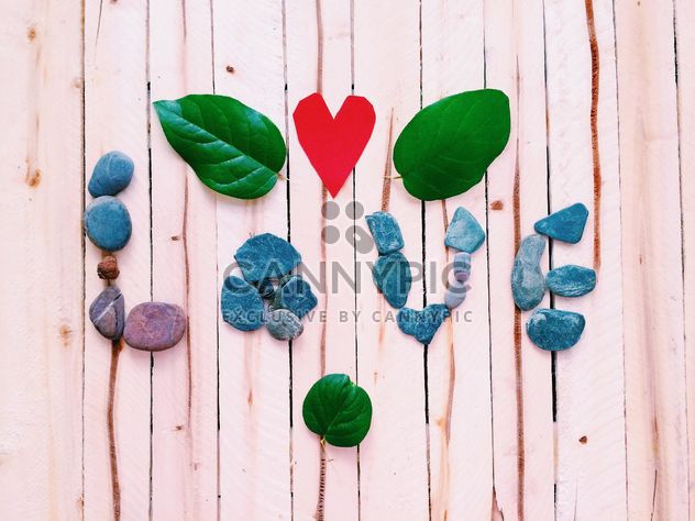 Word Love made of stones on wooden background - бесплатный image #184107