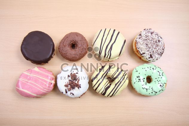 Donuts with different flavors on wooden background - бесплатный image #187797