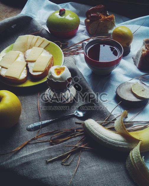 Soft-boiled egg, cheese sandwiches, fruit and tea for breakfast - image gratuit #272217 