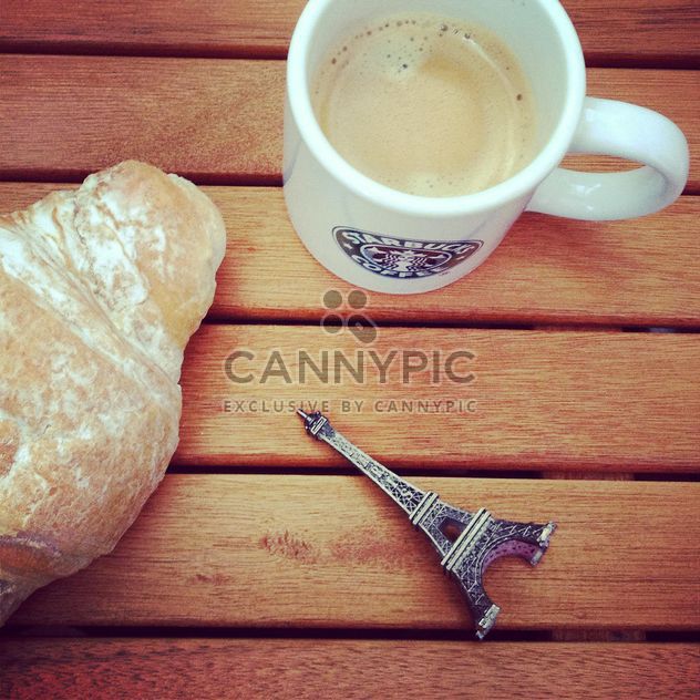 Cup of coffee, croissant and toy Eiffel tower - бесплатный image #329117