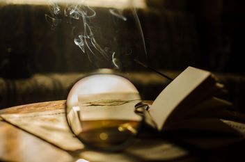 Autumn yellow leaves through a magnifying glass with incense sticks and book - бесплатный image #330407