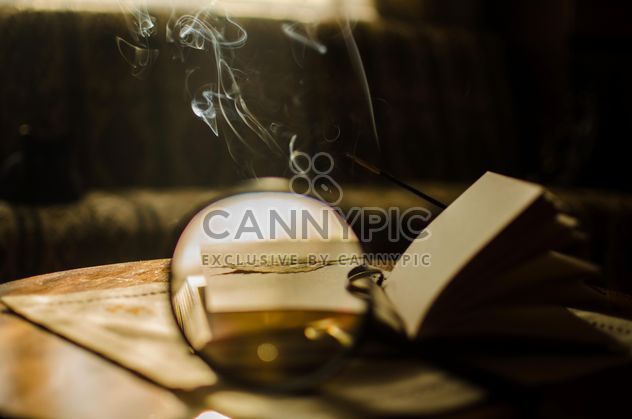 Autumn yellow leaves through a magnifying glass with incense sticks and book - image gratuit #330407 