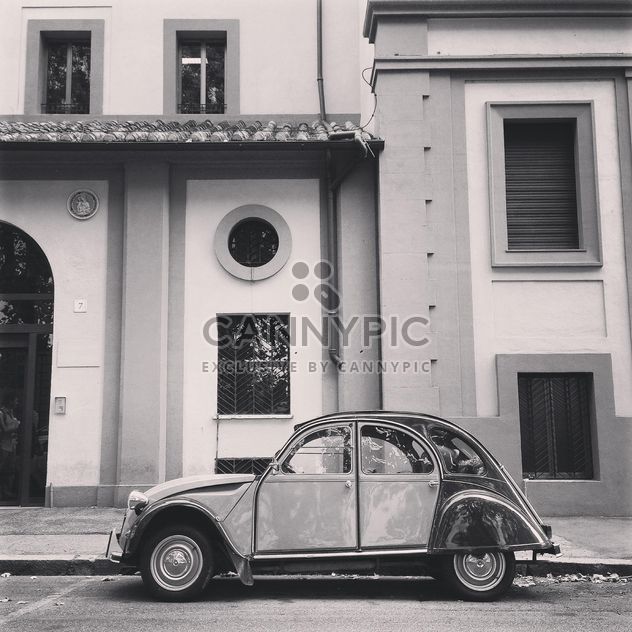 Old Citroen 2CV car parked near the house in the street, black and white - бесплатный image #331867