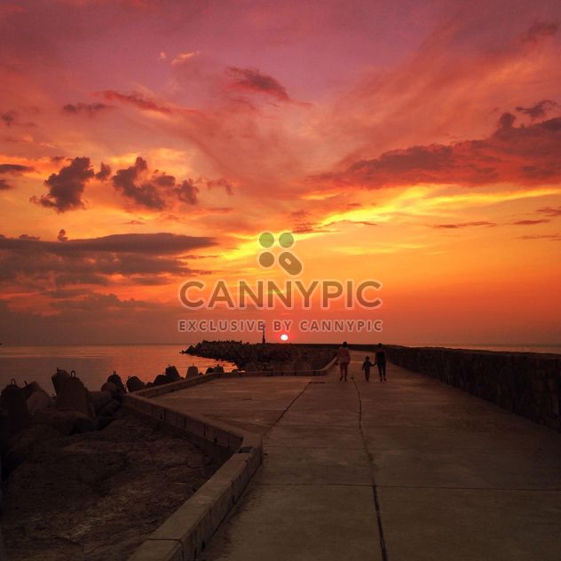 Family on embankment at sunset - Free image #338477
