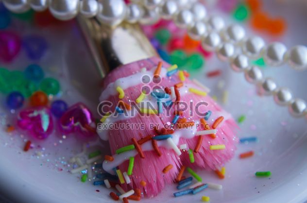 Pink makeup brush and pearls on a plate - бесплатный image #341477