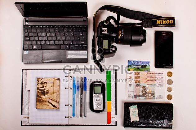 Still life of Laptop, camera, smartphone, office items and money over white background - бесплатный image #342477