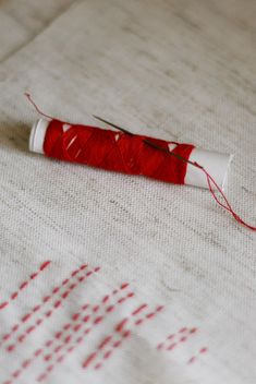 red bobbin thread with needle and stitches - image #342917 gratis