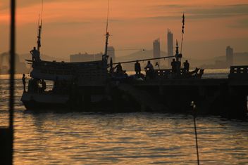 People and boat on sea at sunset - image #344517 gratis