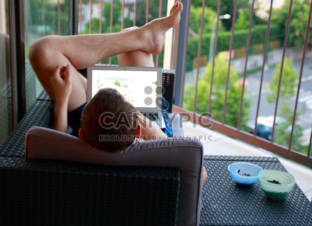 Rear view of man with laptop on balcony - бесплатный image #344537