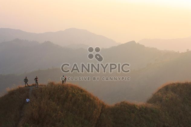 Group of tourists in mountains at sunset - бесплатный image #344577