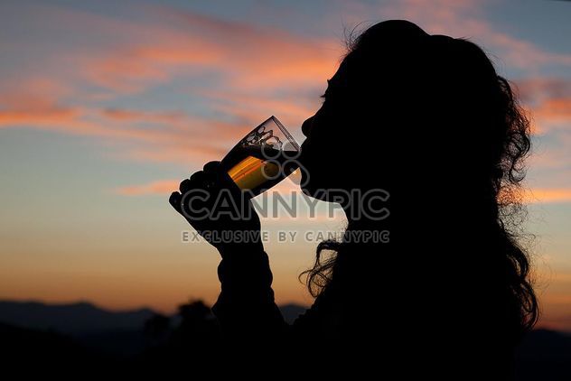 Silhouette of woman drinking beer at sunset - image gratuit #345057 