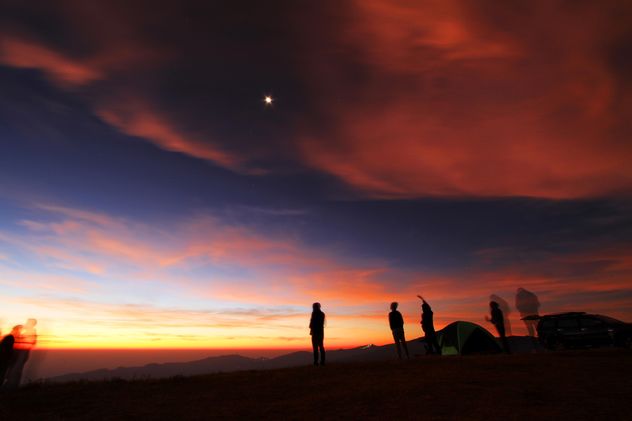Silhouettes of people in mountains at sunset - бесплатный image #345117