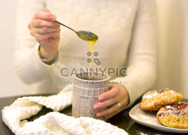 Cup of tea with honey in female hands - image #347967 gratis