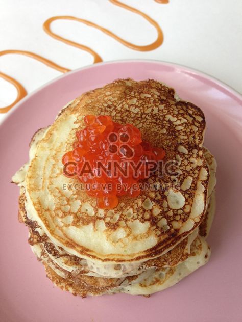 Pile of pancakes with caviar on pink plate - image #348387 gratis