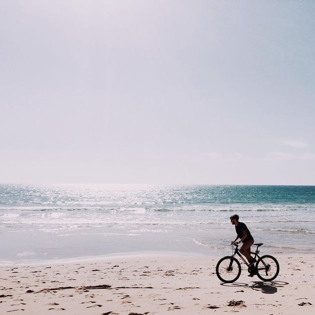 Man riding bicycle along coast - Free image #394807