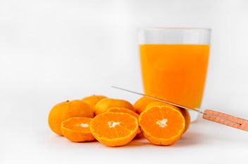 orange juice in glass and knife on white background - Free image #452527