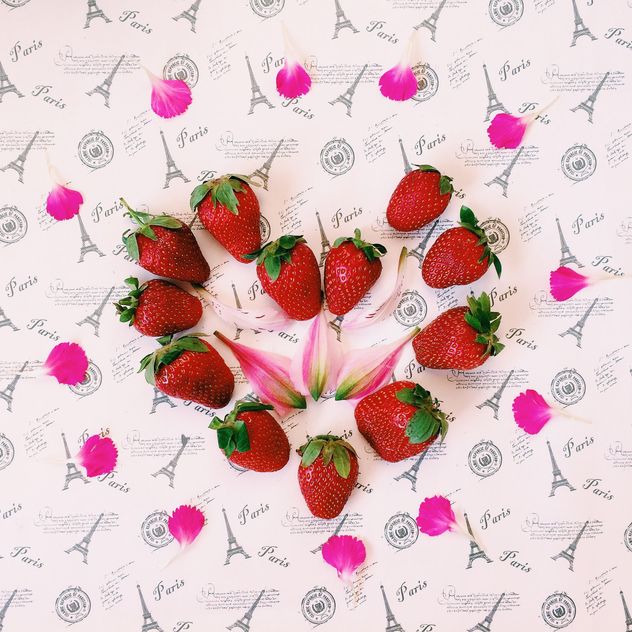 Strawberries and pink petals - image #136467 gratis