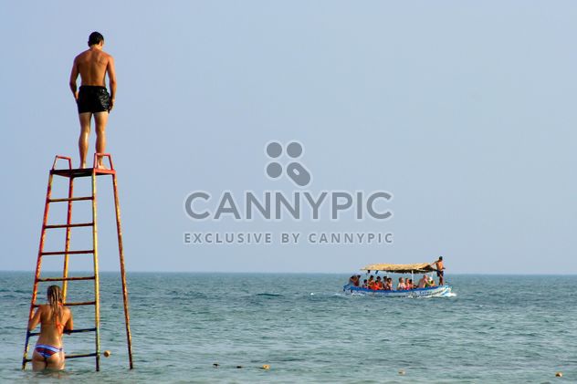 Guys on iron tower and tourists in boat - image #187777 gratis