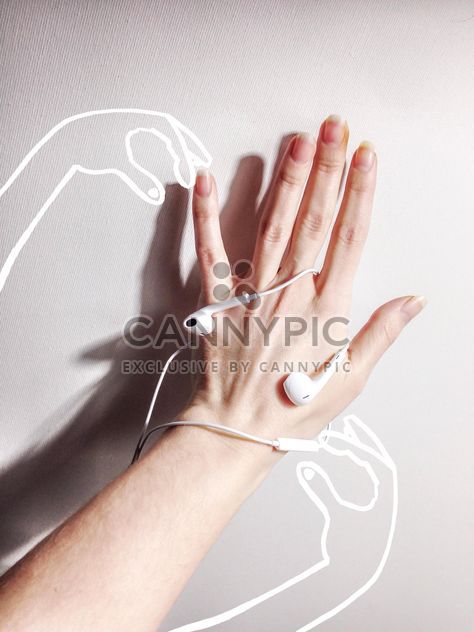 Female hand with earphones on white background - бесплатный image #198997