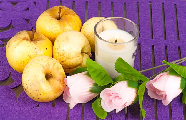 Yellow apples, roses and candle on purple background - бесплатный image #272527