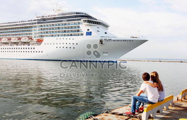 Couple looking at large cruise ship at sea - image #301597 gratis