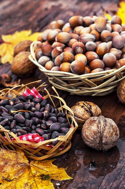 Nuts in baskets on wooden background - бесплатный image #301997
