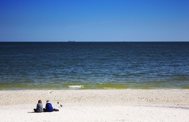 Couple sittting on sandy beach - Kostenloses image #303347