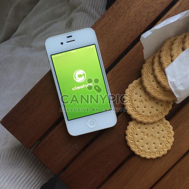 Cookies and smartphone on table - бесплатный image #329127