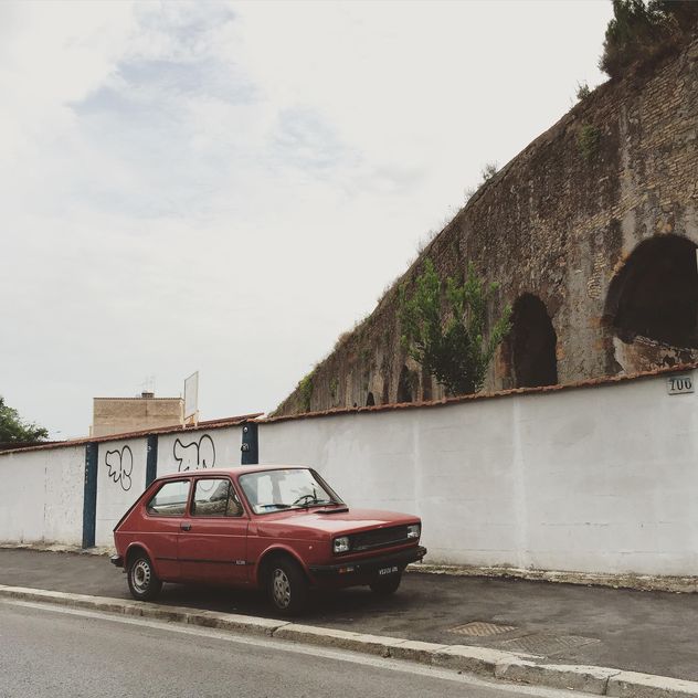 Old Fiat car parked near ancient arch - бесплатный image #332397