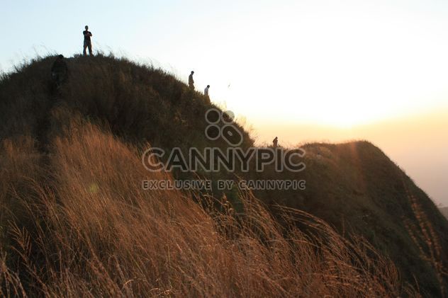 People on rock at sunset - image gratuit #338507 