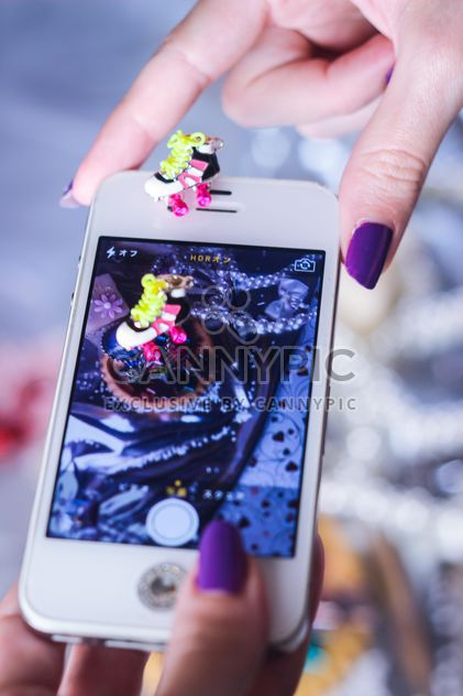 Smartphone decorated with tinsel in woman hands - image #342187 gratis