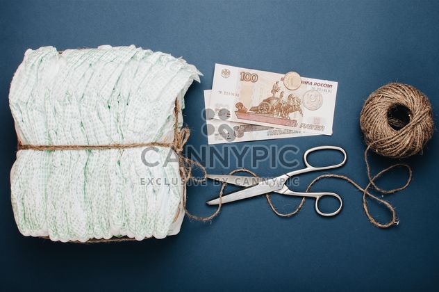 Diapers, skein of thread, scissors and money on blue background. Diapers for 3 dollars, Cheboksary, Russia - Free image #342557