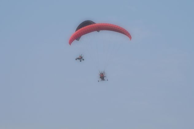 Flying paramotors in blue sky - image #347017 gratis