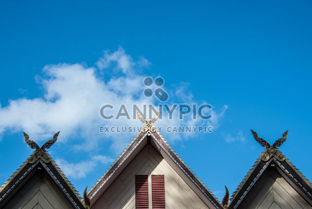 Roof of Thai temple against blue sky - бесплатный image #347307