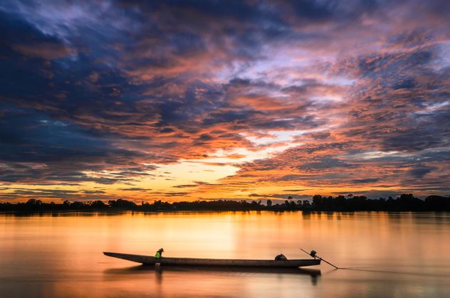 Man in boat at sunset - image #451937 gratis