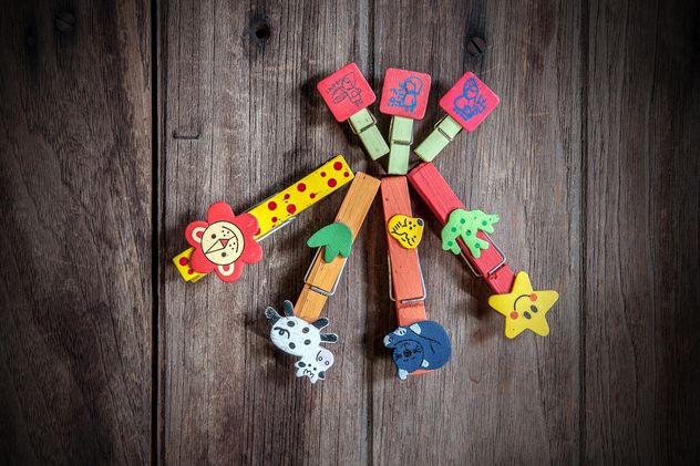 Colored clothespins on wooden background - image #452417 gratis