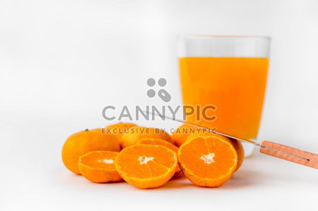 orange juice in glass and knife on white background - image gratuit #452527 