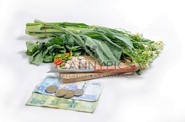 garlic and chili peppers on a wooden desk and near money on white background - image #452537 gratis