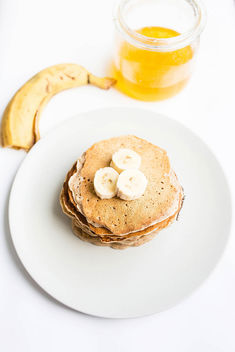Top view of stacked vegan pancakes with honey and banana - бесплатный image #458257